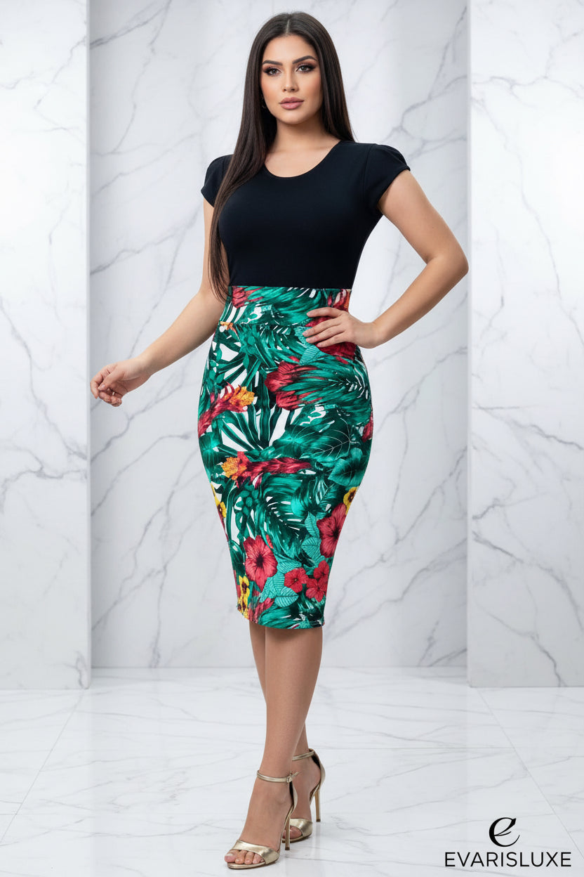 Person wearing a black top and colorful floral skirt in a room with wooden walls and pink flowers.