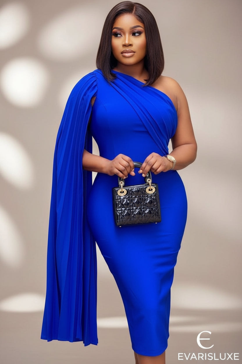 Woman in a blue dress holding a handbag against a decorative background