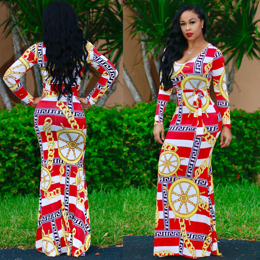 Woman wearing a red, white, and gold patterned dress with a reflective surface.