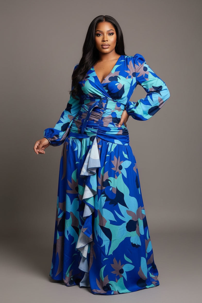 Woman wearing a blue floral dress standing in front of colorful fabric displays.