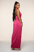 Woman wearing a pink halter neck dress on a white background