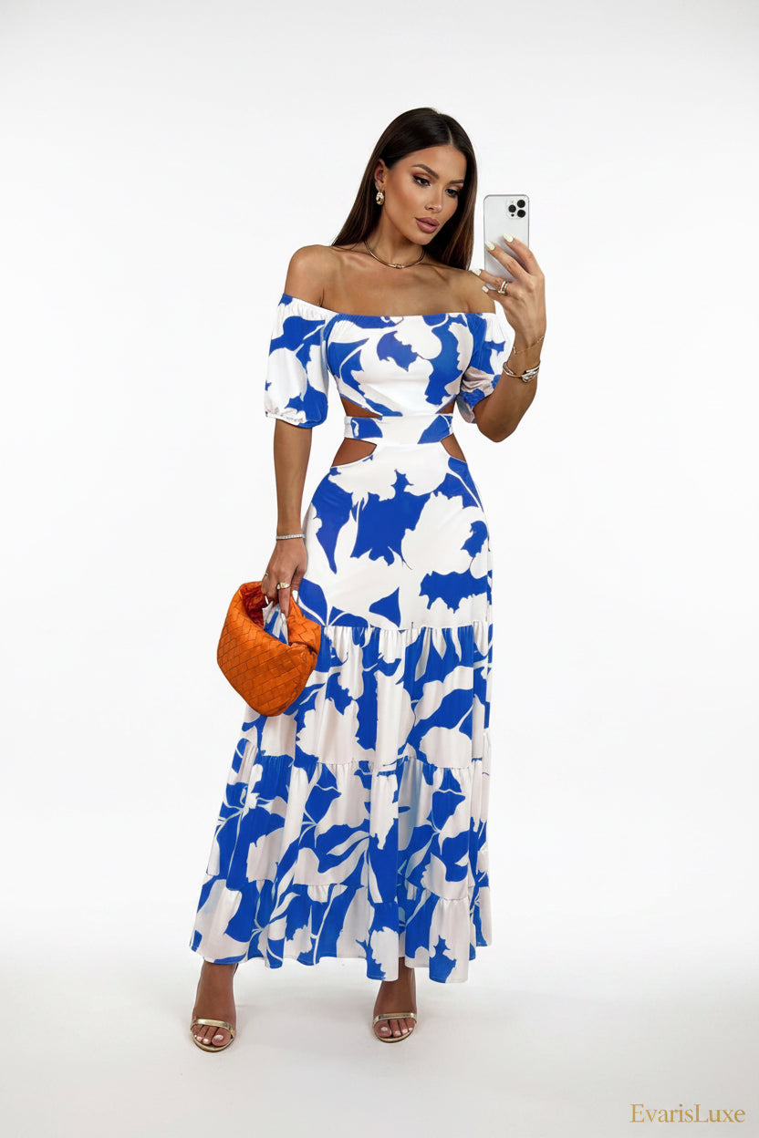 Woman wearing a blue and white floral dress holding an orange clutch.