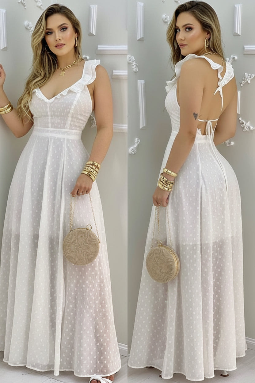 Woman wearing a white polka dot dress holding a round beige handbag.