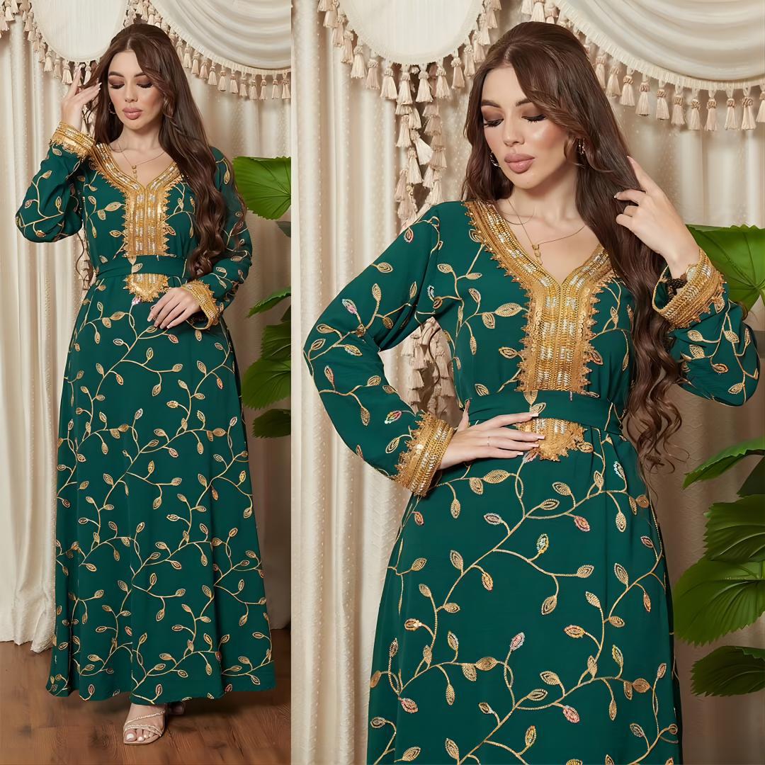 Woman wearing a green and gold embroidered dress in a decorated room.