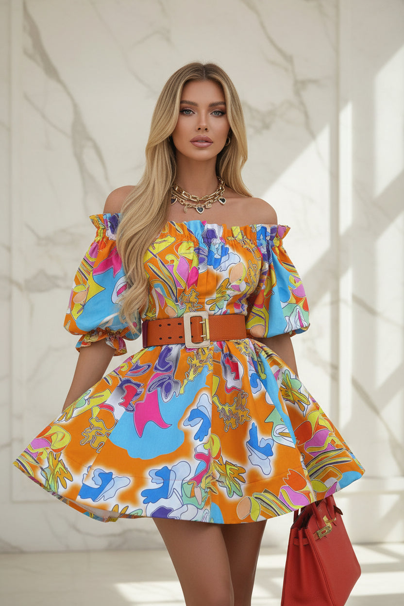 Woman wearing a colorful dress with a red handbag in an outdoor setting