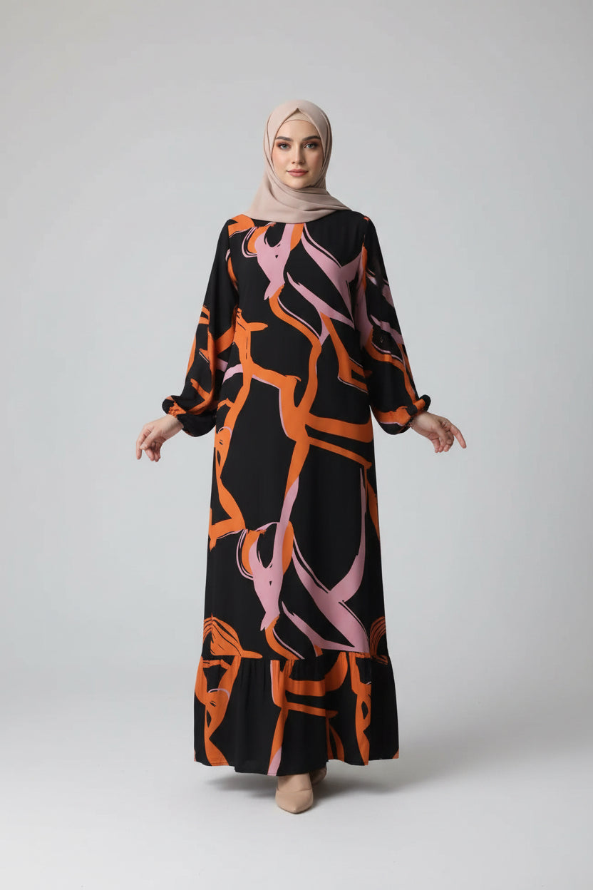 Person wearing a black dress with orange and pink abstract patterns, standing in a room.