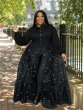 Woman wearing a black dress with layered skirt and buttons outdoors.