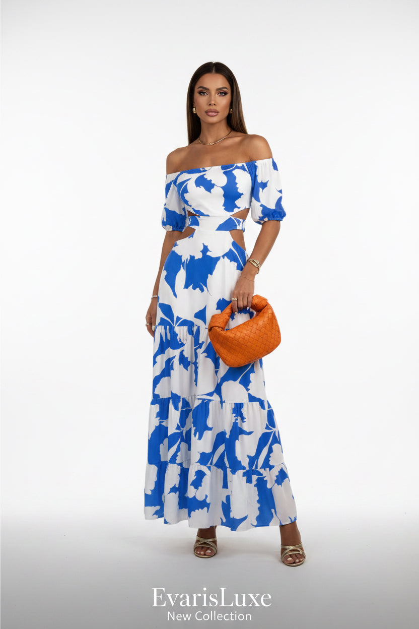 Woman wearing a blue and white floral dress holding an orange clutch.