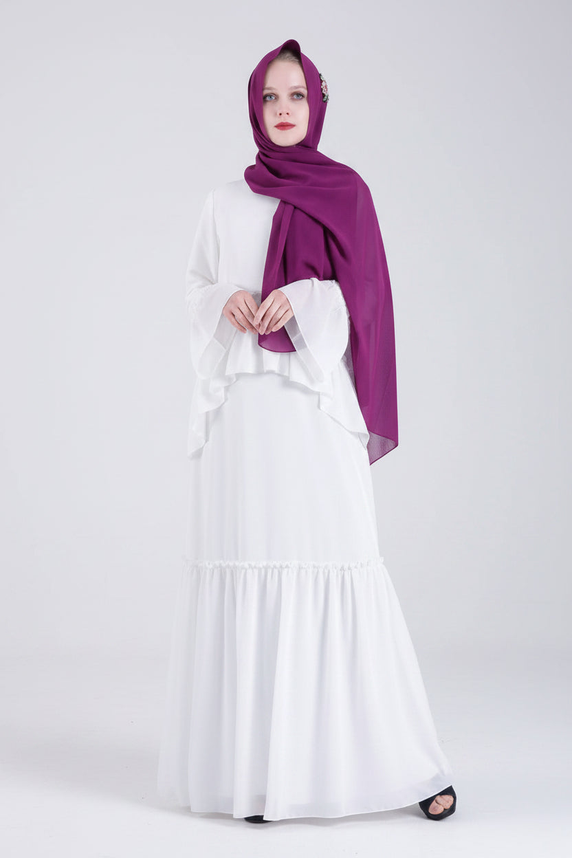 Woman wearing a white dress and purple hijab on a white background