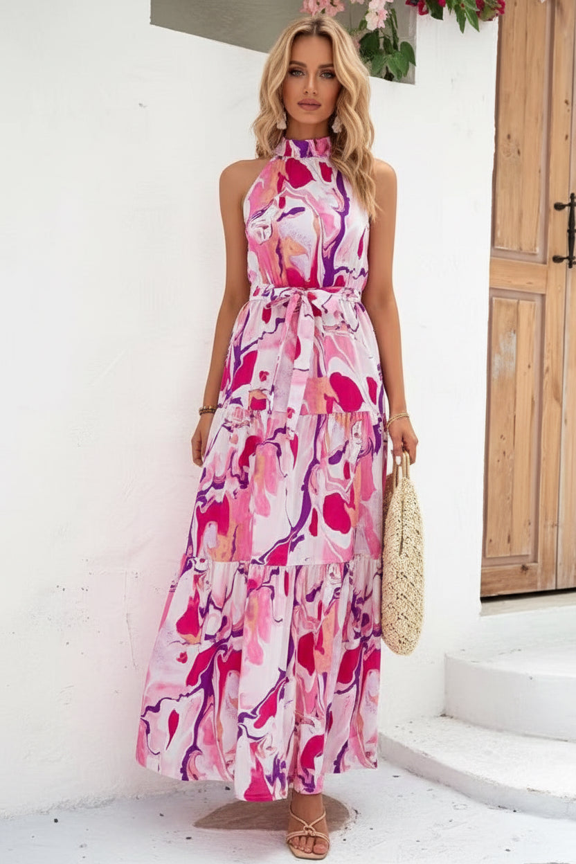 Woman wearing a pink floral dress holding a straw bag indoors.