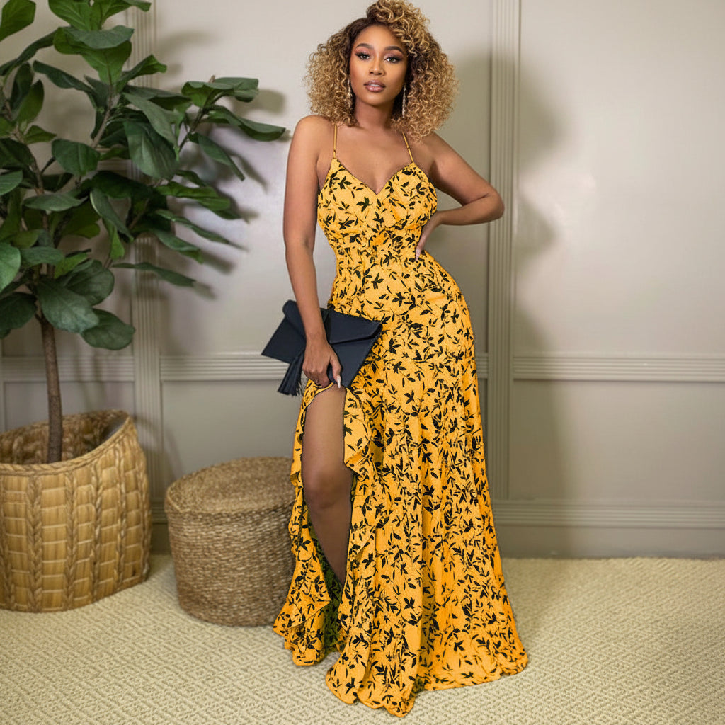 Woman in a yellow floral dress with a black clutch in an indoor setting