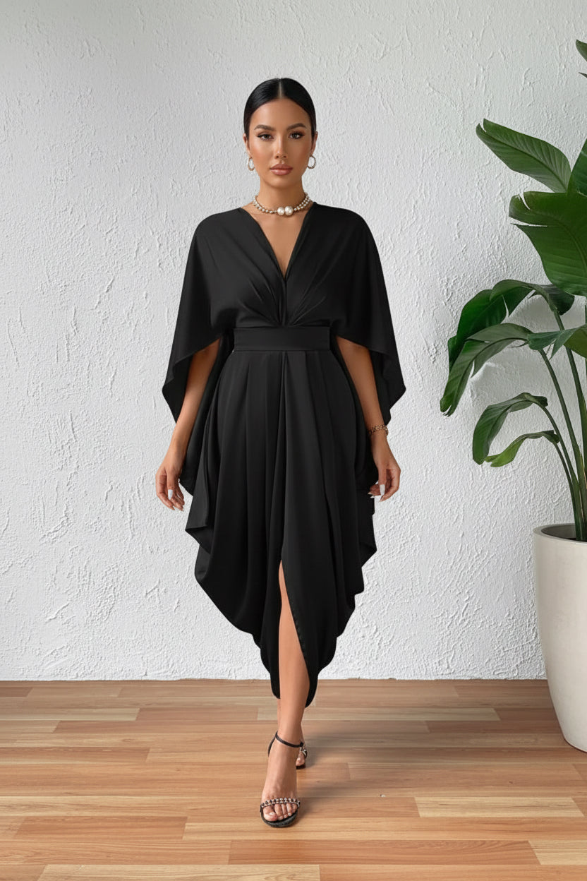 Person wearing a black dress with a draped design on a wooden floor.