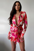 Red and pink patterned dress on a plain background