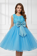 Blue dress with floral top and large bow on a white background