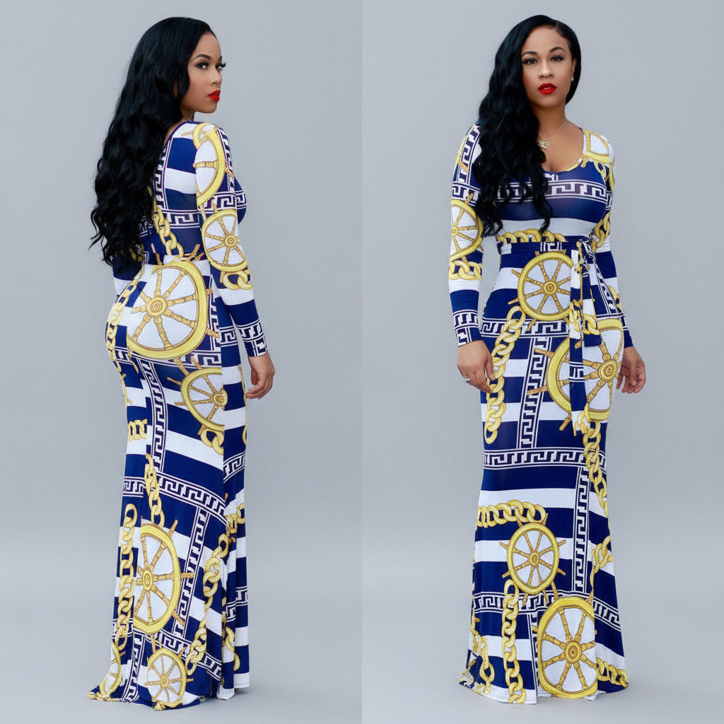 Woman wearing a blue and white patterned dress with gold accents outdoors.