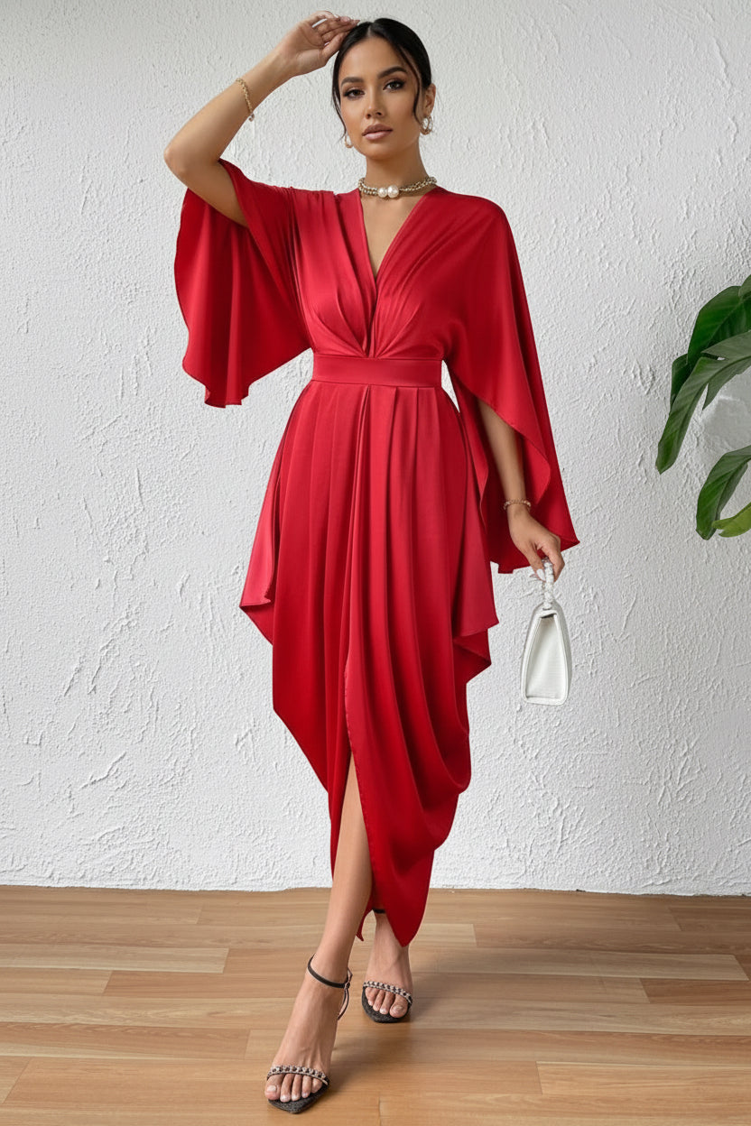 Red dress with wide sleeves worn by a person against a white wall.