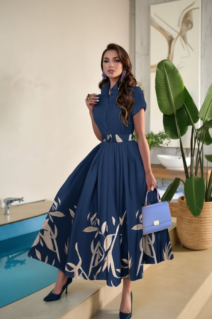 Woman in a blue dress with a floral pattern holding a blue handbag by a pool.