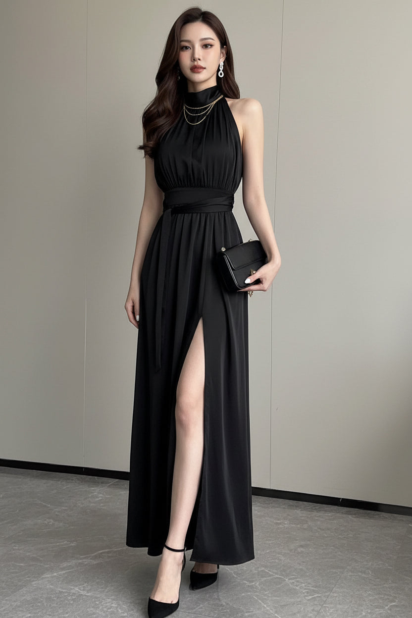 Woman wearing a black sleeveless dress with a high slit on a plain background