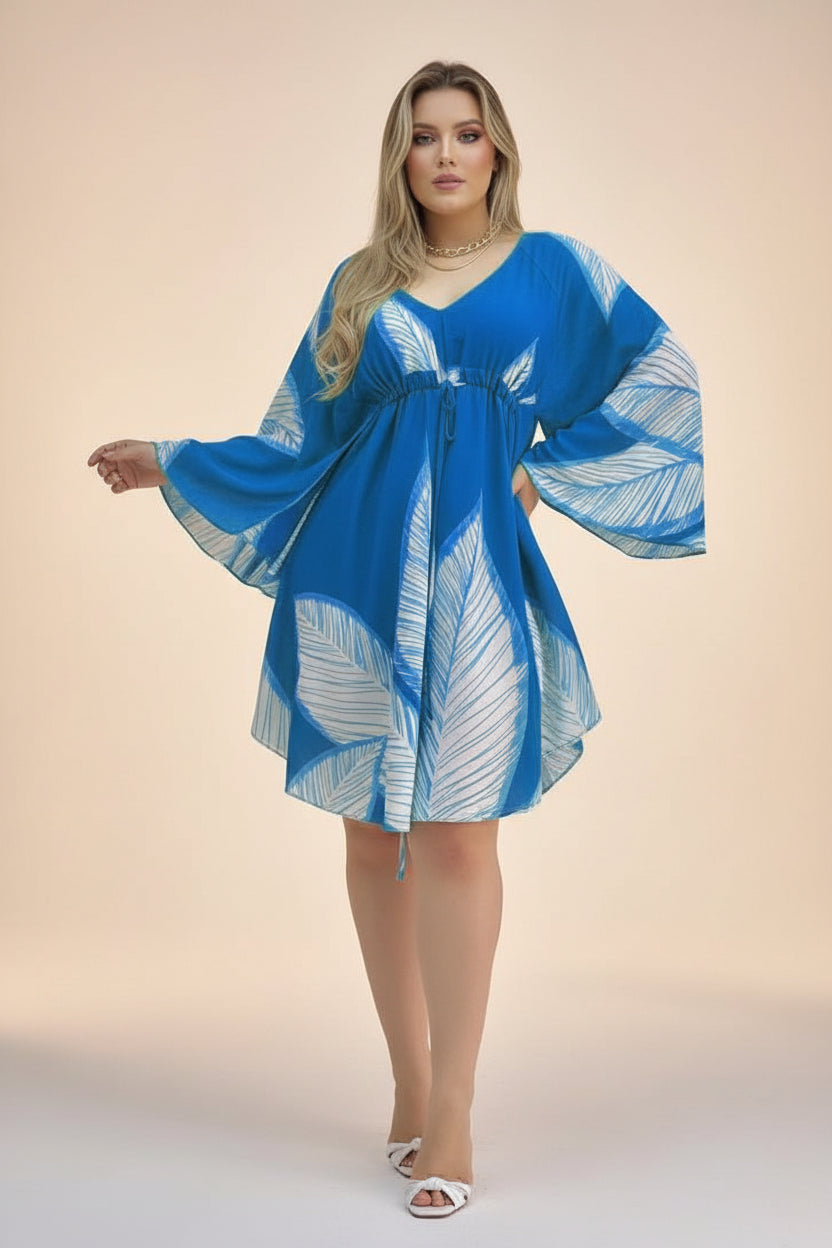Woman wearing a blue and white patterned dress with a matching cover-up against a neutral background.