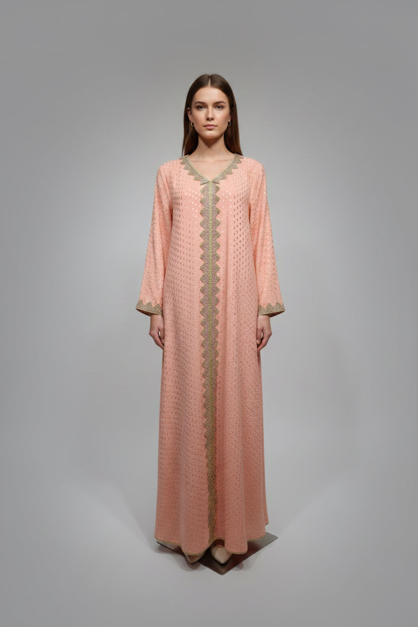 Peach-colored dress with gold embroidery on a mannequin against a white paneled wall.
