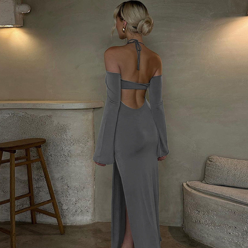 Woman in a gray evening gown standing in a room with a rustic interior.