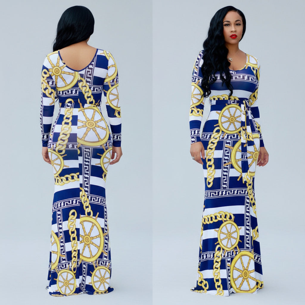 Woman wearing a blue and white patterned dress with gold accents outdoors.