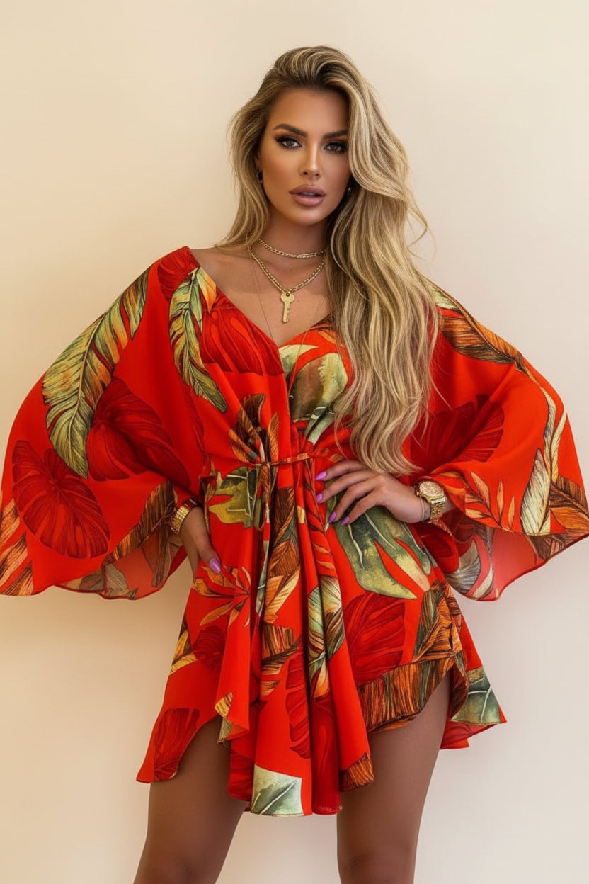 Red dress with tropical leaf pattern worn by a person on a beige background
