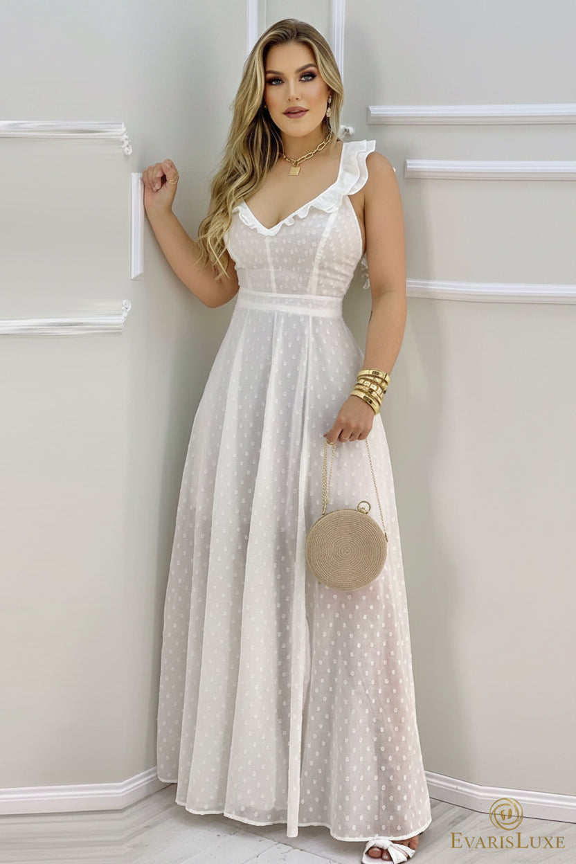 Woman wearing a white polka dot dress holding a round beige handbag against a plain background