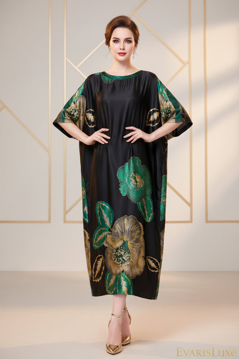 Woman wearing a black dress with green floral patterns sitting on a gray couch.