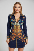 Woman wearing a navy blue dress with floral and peacock feather pattern.