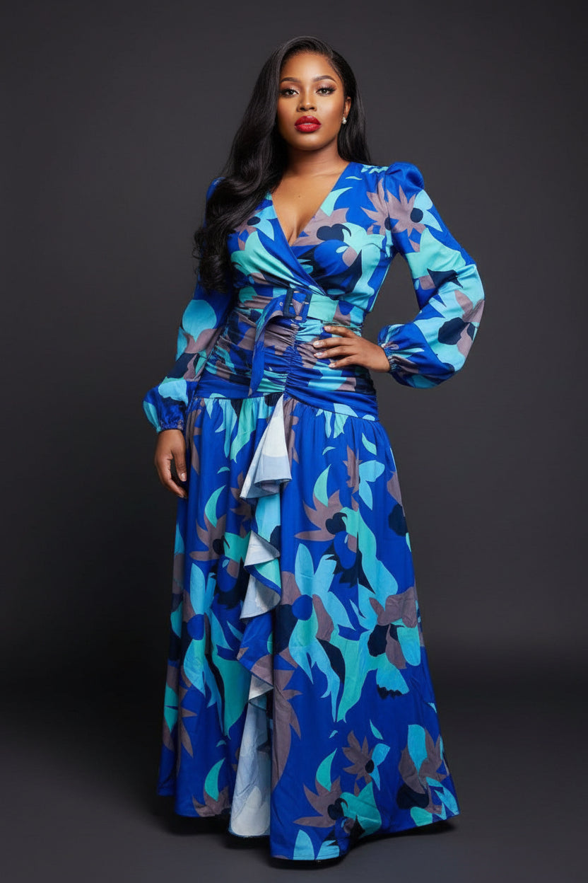Woman wearing a blue floral dress standing in front of colorful fabric displays.