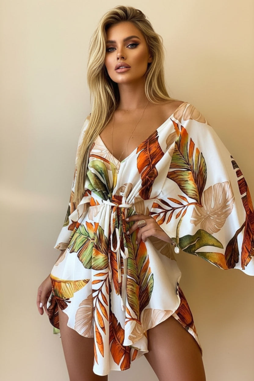 Woman wearing a tropical leaf patterned dress against a neutral background