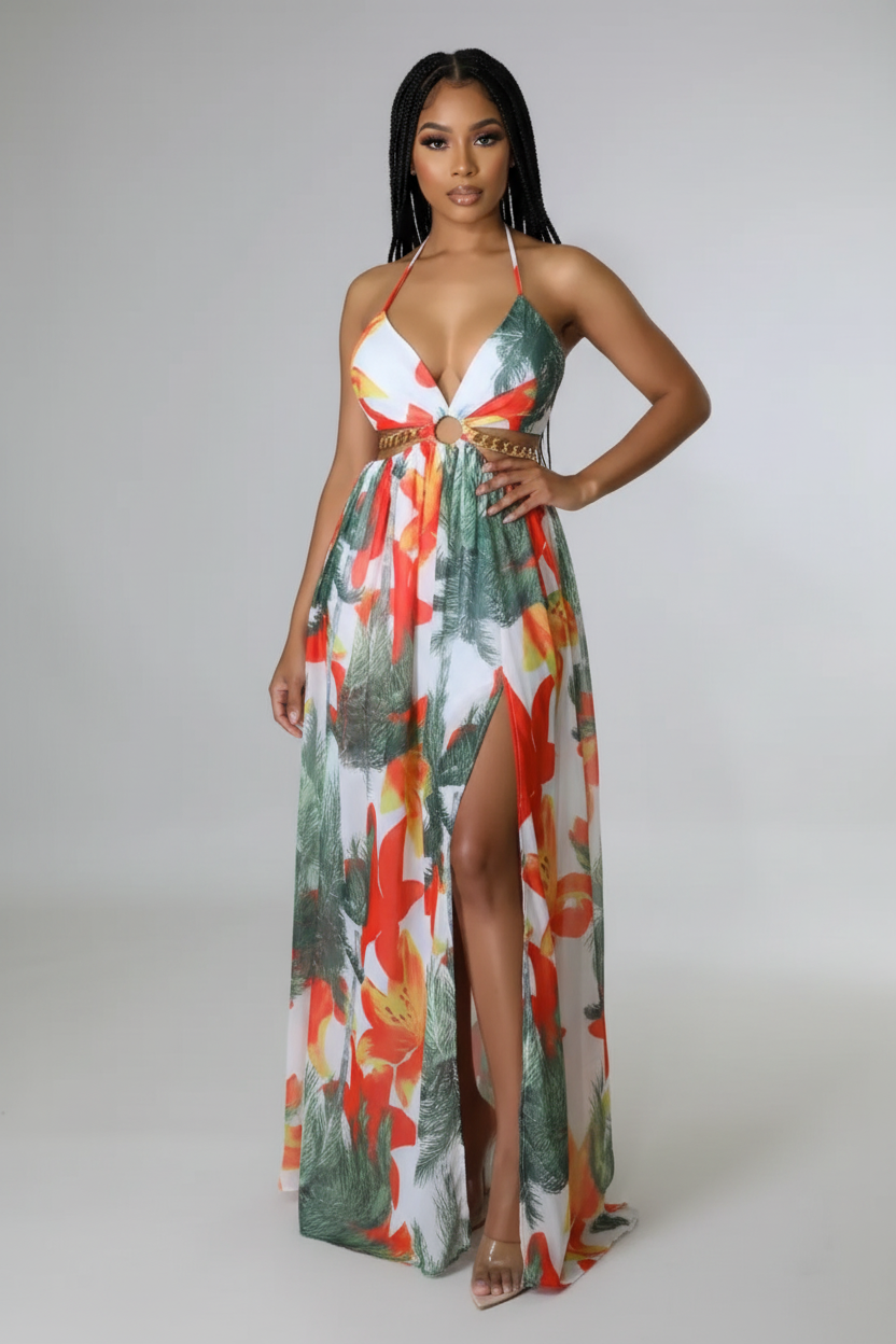 Woman wearing a colorful floral dress with a high slit on a plain background