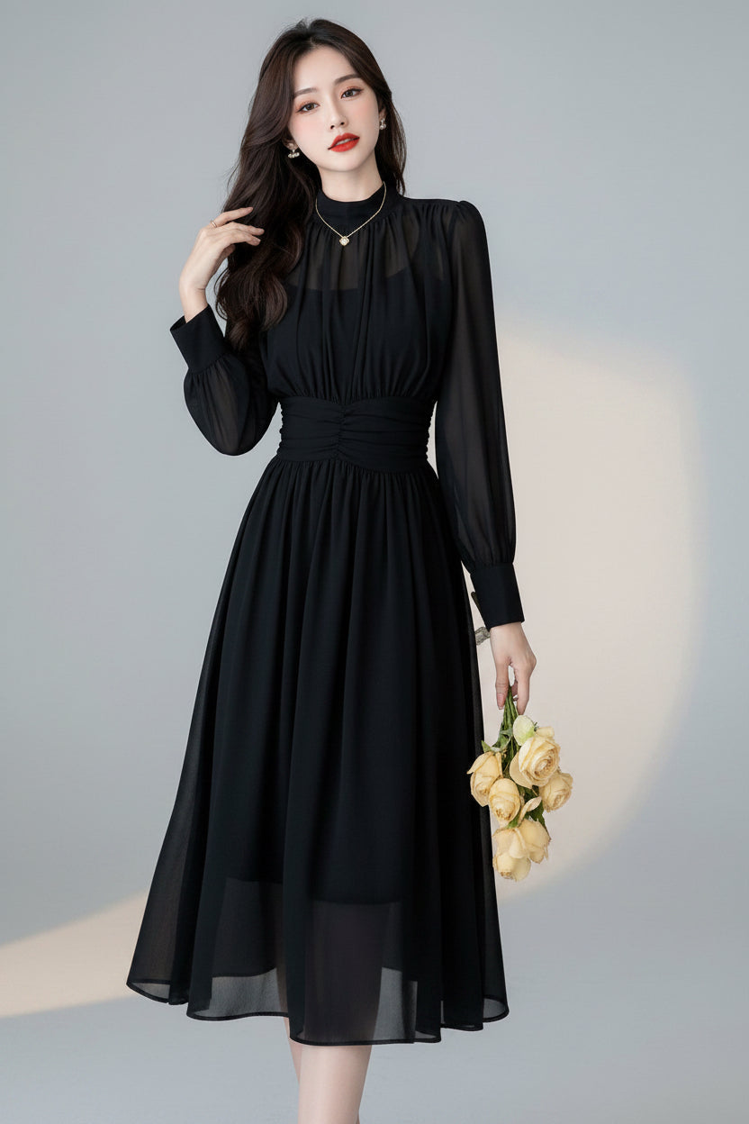 Woman in a black dress holding flowers in a kitchen.