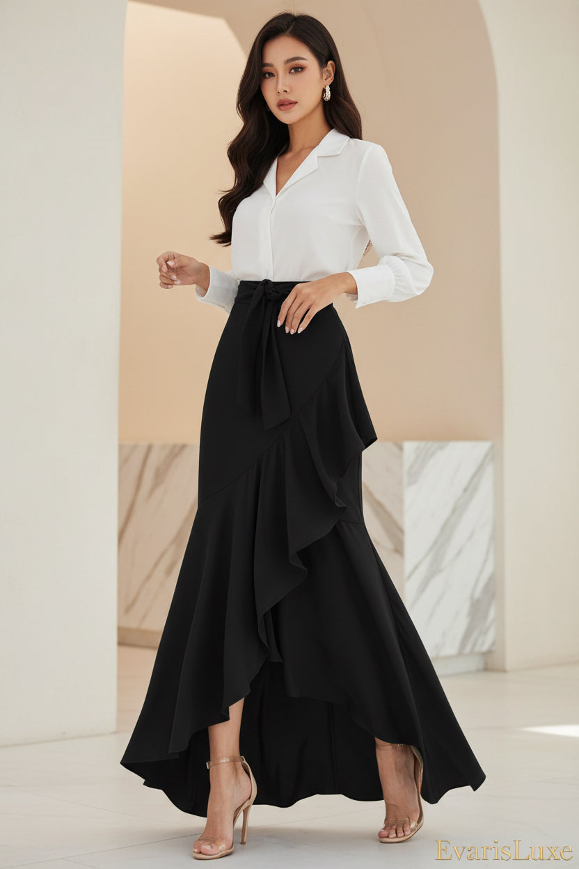 Person wearing a black ruffled skirt and white top in an indoor setting.