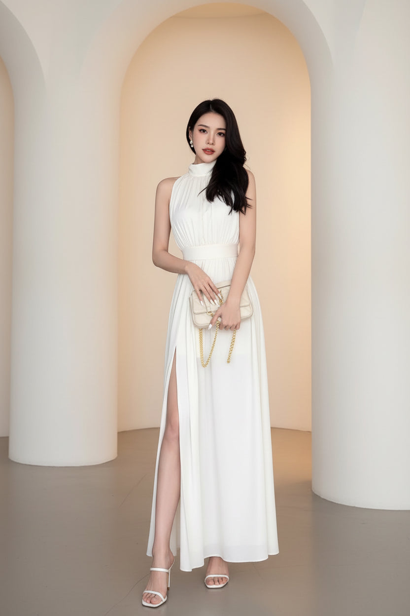 Woman in a white dress holding a matching handbag in an indoor setting.
