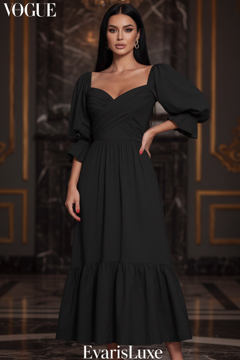 Black dress with puffed sleeves worn by a person standing against a white wall with green foliage.
