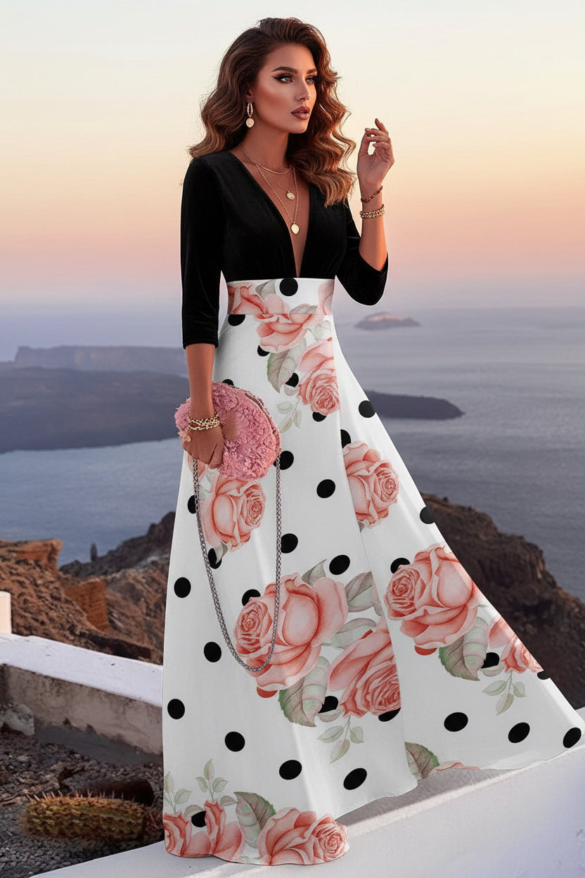 Woman in a floral dress standing on a cliff overlooking the ocean with a cactus plant nearby.