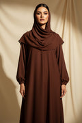Brown dress hanging on a green rack against a curtain backdrop