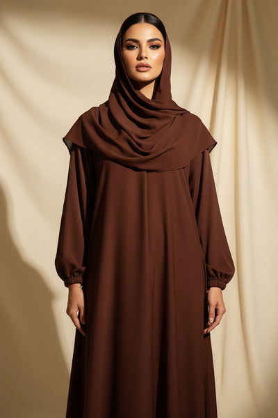 Brown dress hanging on a green rack against a curtain backdrop