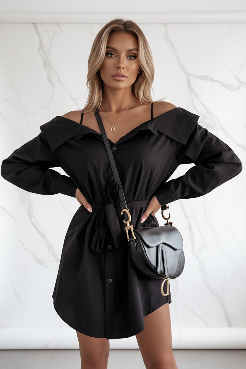 Person wearing a black off-shoulder dress with a matching handbag indoors.
