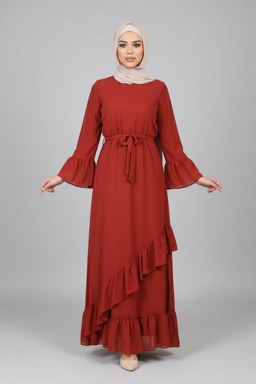 Woman wearing a red dress with ruffled details in front of a brick wall.