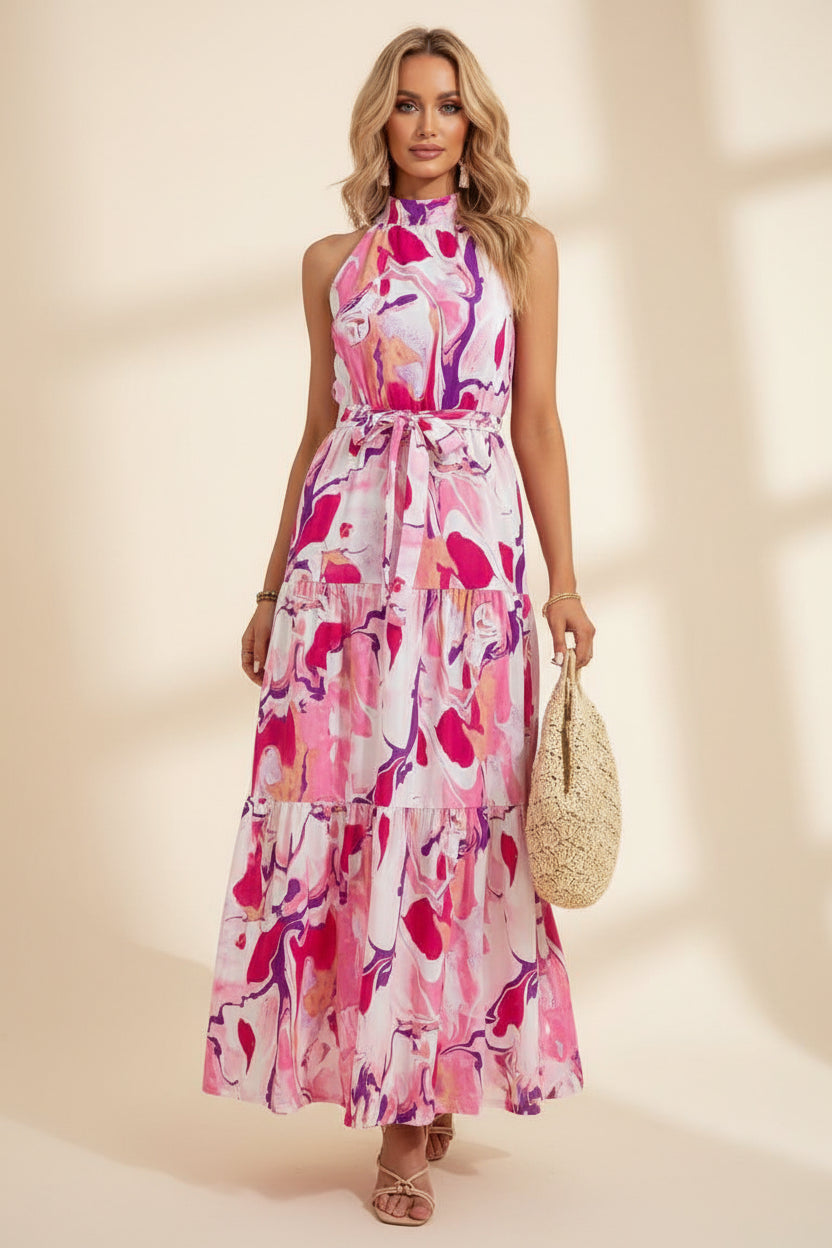 Woman wearing a pink floral dress holding a straw bag indoors.