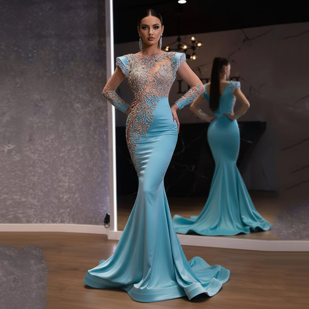 Woman wearing a blue evening gown with intricate silver detailing in a room setting.