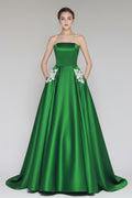 Green strapless gown with floral details on a gray background