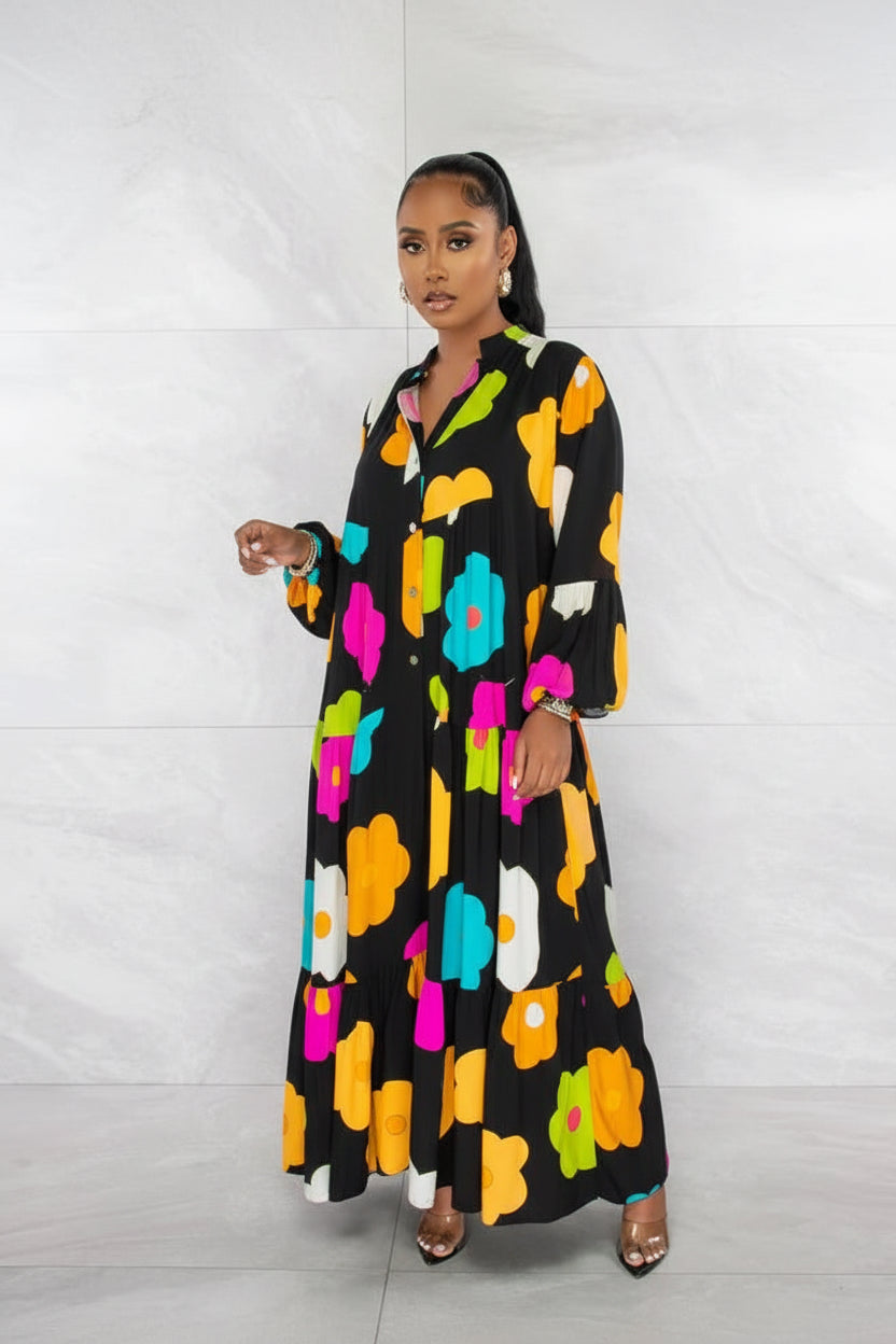 Woman wearing a black dress with colorful floral patterns against a white background