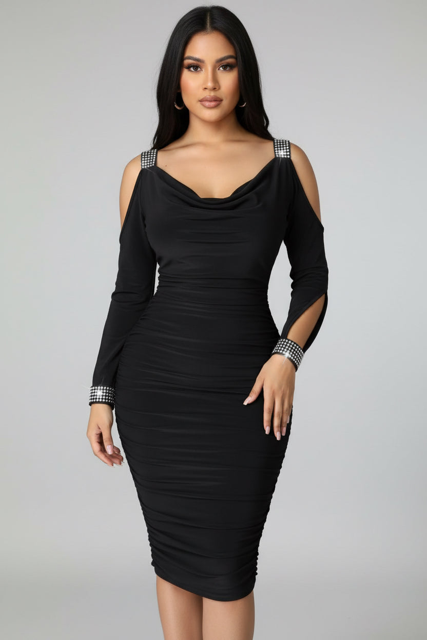 Black dress with cut-out shoulders and ruched details on a plain background
