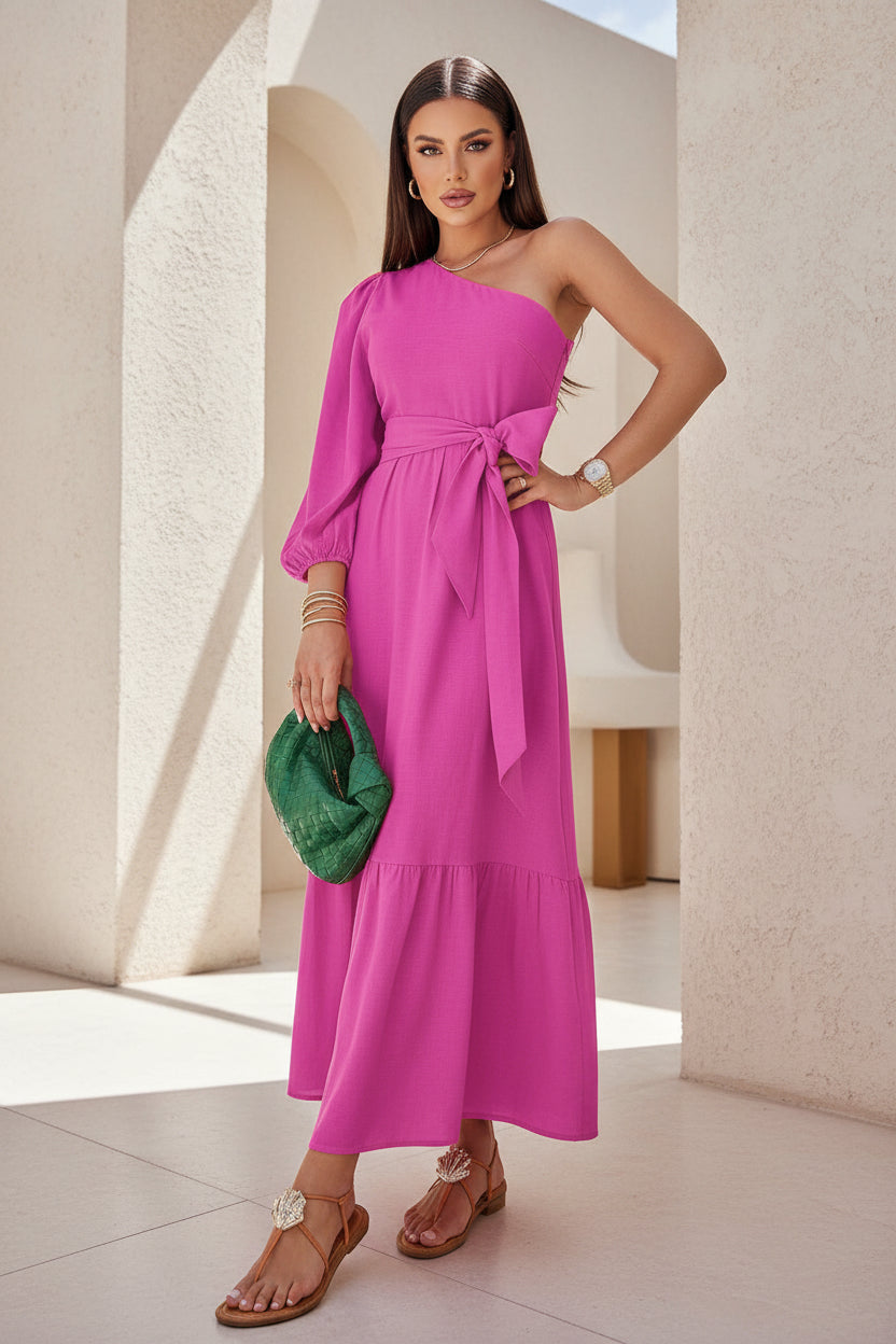 Woman in a pink dress holding a green clutch in front of tropical plants