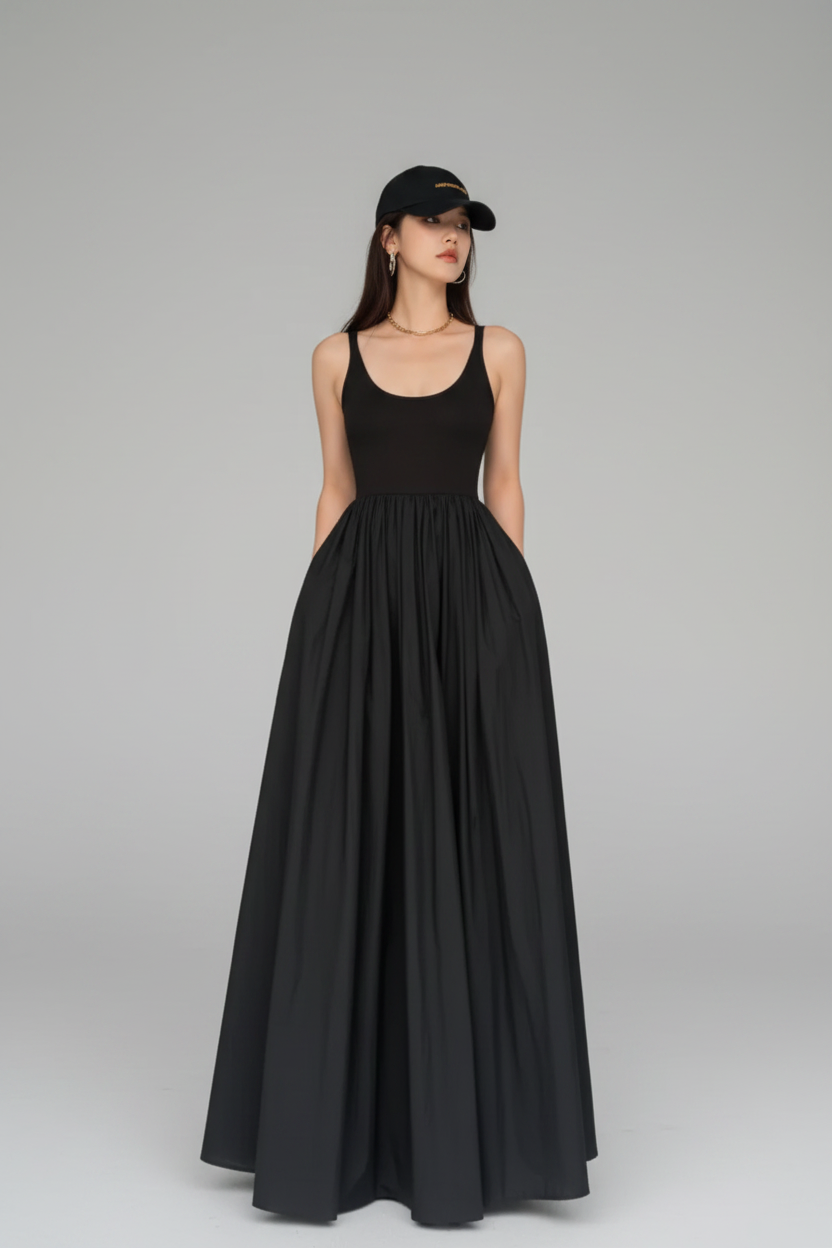 Woman wearing a black sleeveless dress and cap in front of a glass block wall.