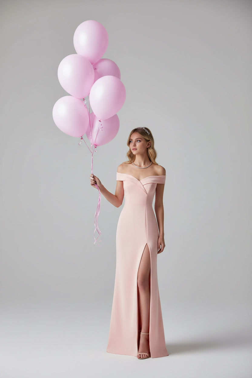 Woman in a pink dress holding balloons on a boardwalk with ocean and cityscape in the background